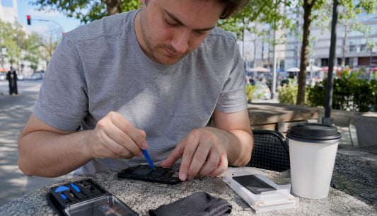 Man replacing phone battery at kitchen table